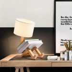 Kreativer Kerzenleuchter mit integrierter Buchstütze und Lampe, modernes Dekorstück für stilvolle Raumgestaltung.
