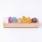 Verschiedene bunte Kristalle aus Mineralien, die auf einer Holzplatte angeordnet sind, ideal für wissenschaftliche Dekorationen und Lernzwecke.
