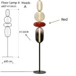 Moderne Stehlampe mit vier bunten, geometrischen Glasköpfen in Rot, Weiß, Schwarz und Transparent, ideal für stilvolle Raumdekoration.