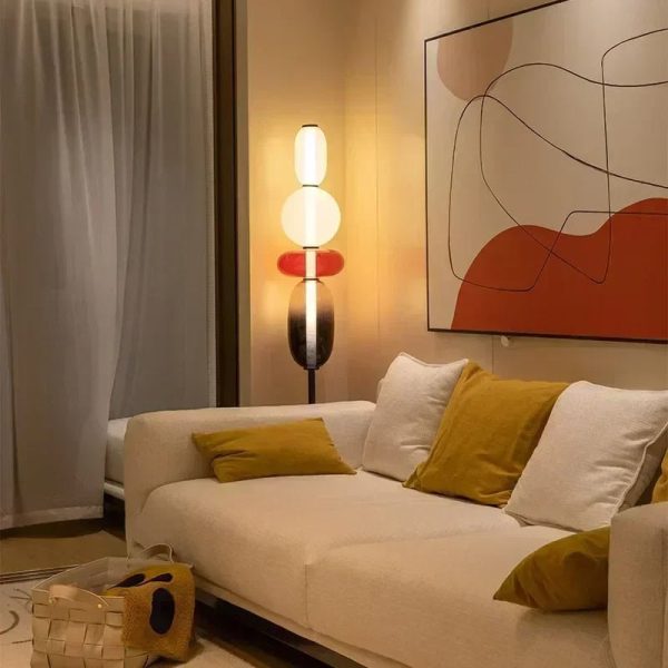 Stilvolles Wohnzimmer mit moderner Stehlampe, abstraktem Wandbild und gemütlicher Couch mit Kissen, ideal für elegante Inneneinrichtung.