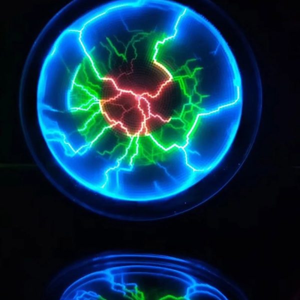 Elektrische Tesla-Kugel mit blauen, grünen und roten Blitzen, die in einer dunklen Umgebung leuchten, zeigt beeindruckende elektrische Entladungen.