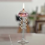 Elegante Teelichtkerze in Form einer Glas-Jellyfish mit spiralförmigen Tentakeln, ideal für wissenschaftliche Dekorationen und stimmungsvolle Beleuchtung.
