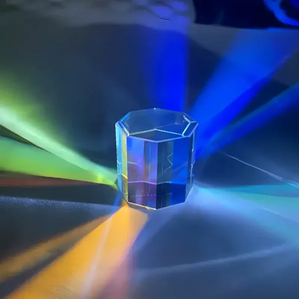 Kristallglas mit bunten Lichtreflexen, das auf einer glatten Oberfläche steht, erzeugt bunte Lichtspiele in verschiedenen Farben.