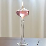 Glas-Versuchsaufbau mit Kerzenflamme, zeigt eine wissenschaftliche Demonstration mit einer flammenden Kerze in einem transparenten Glasbehälter.