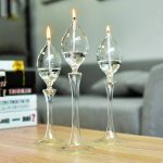 Elegante Glas-Objekte mit brennenden Kerzen, ideal für wissenschaftliche Dekorationen und moderne Raumgestaltung. Perfekt für ein stilvolles Ambiente.