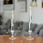 Zwei Kerzen in transparenten Glasbehältern mit spiralförmiger Dekoration, ideal für wissenschaftliche Dekorationen oder moderne Raumgestaltung.