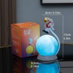 Beleuchtetes Nachtlicht mit Astronautenfigur auf einer leuchtenden Kugel, ideal für Kinderzimmer und wissenschaftliche Dekorationen.