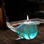 Dekoratives wissenschaftliches Glasobjekt in Form eines Wals, das als Kerzenhalter dient, mit brennender Kerze auf der Oberseite, ideal für wissenschaftliche Dekorationen.