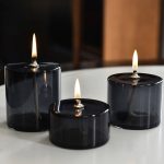 Elegantes Set aus drei schwarzen Glaskerzen mit Flammen, ideal für stilvolle Dekorationen und wissenschaftliche Präsentationen.