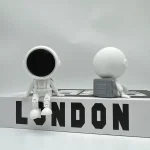 Niedliche Designfigur eines Astronauten mit Mond und Raumkapsel, ideal für Science-Fiction- und Weltraumdekorationen, perfekt für Sammler und Science-Fans.