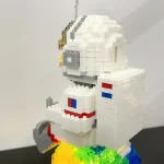 Detailaufnahme eines LEGO-Raumschiffs mit weißen, blauen, roten und goldenen Elementen, auf einem schwarzen Untergrund.
