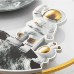 Schlüsselanhänger in Form eines Astronauten, gefertigt aus Holz mit goldfarbenen Akzenten, ideal für Weltraum- und Astronomie-Enthusiasten.