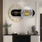 Moderne Wanduhr mit goldenen Ziffern und schwarzem Zifferblatt, kombiniert mit einem dekorativen, schwebenden Kunstobjekt in einem stilvollen Raum.