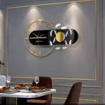 Schwebende Wanduhr mit schwarzem Zifferblatt, goldenen Zahlen und Zeigern, kombiniert mit einem dekorativen Element aus weißen Federn, ideal für moderne Inneneinrichtung.