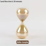 Elegante Sanduhr aus goldenem Glas, zeigt eine Sandflusszeit von 30 Minuten, ideal für wissenschaftliche Dekorationen und Lernzwecke.
