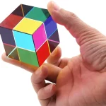 Hand hält einen bunten, reflektierenden Würfel mit verschiedenen Farben auf jeder Seite, symbolisiert Wissenschaft und Innovation.