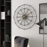 Moderne geometrische Wanduhr mit schwarzem Rahmen und goldenen Zeigern, ideal als stilvolles Dekor für Wohnzimmer oder Büro.