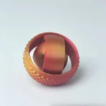 Wissenschaftliches Gadget in Rot mit strukturierter Oberfläche und metallischer Textur, ideal für Dekoration oder wissenschaftliche Anwendungen.