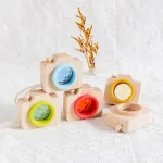 Holzspielzeugkamera mit bunten Objektivringen, ideal für Kinder zum kreativen Spielen und Lernen über Fotografie, handgefertigt, umweltfreundlich, langlebig.