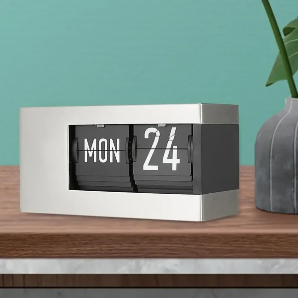 Moderne Flip-Uhr auf einem Holzschreibtisch zeigt Datum und Wochentag, ideal für wissenschaftliche und dekorative Zwecke.