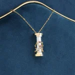 Elegantes wissenschaftliches Schmuckstück, ein Halskettchen mit einem Miniatur-Experimentierglas, verziert mit kleinen Kristallen, auf dunkelblauem Hintergrund.