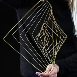 Elegantes geometrisches Schmuckstück aus goldfarbenem Draht, das komplexe, verschachtelte Formen bildet, perfekt für moderne Dekorationen oder als einzigartiges Accessoire.