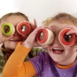 Zwei lachende Kinder mit bunten Teleskopen, die Spaß an wissenschaftlichen Entdeckungen haben, ideal für Bildungs- und Spielzwecke.