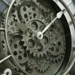 Detailliertes Bild eines mechanischen Uhrwerks mit sichtbaren Zahnrädern und Zeigern, das die komplexe Technik und Präzision von Zeitmessern zeigt.