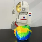 LEGO-Raumfahrer mit leuchtendem Helm auf einer bunten Regenbogen-Base, detailreiche Baukunst, ideal für Science-Fans und Dekorationen.