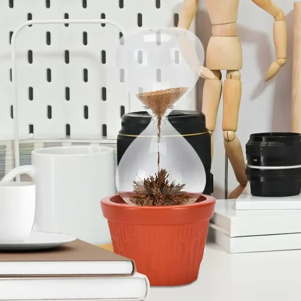 Innovative Sanduhr mit Pflanze, die in einem roten Blumentopf wächst, als dekoratives wissenschaftliches Gadget für moderne Innenräume.