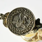 Antikes Drachenmedaillon mit detailliertem Drachenmotiv und keltischem Knotenmuster, aus silberfarbenem Metall gefertigt.