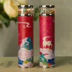 Zwei Feuerwerkskörper mit chinesischem Motiv, verziert mit bunten Wolken, Drachen und Bergen, auf einer neutralen Oberfläche.
