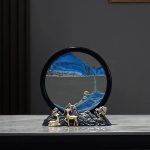 Dekoratives Wasser- und Bergmotiv mit Spiegel, bestehend aus einer runden Spiegelplatte, blauen Bergstrukturen und kleinen metallischen Figuren, ideal für wissenschaftliche oder dekorative Zwecke.