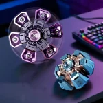 Zwei metallene, sternförmige Spielzeuge mit LED-Beleuchtung, eines in Lila und Schwarz, das andere in Blau und Silber, auf einem dunklen Schreibtisch mit Tastatur im Hintergrund.