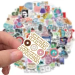 Bunter Gummibärchen-Anhänger mit Aufschrift "Gummibärchen Anhänger, Gummi, Arbeit für Donuts" vor einem Hintergrund voller bunter Sticker und Dekorationsartikel.