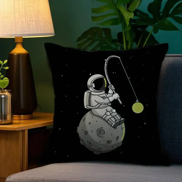 Kissen mit Astronautenmotiv, der auf einem kleinen Planeten sitzt und eine Angel hält, vor einem schwarzen Hintergrund mit Sternen. Perfekt für Science-Fiction- und Weltraumfans.