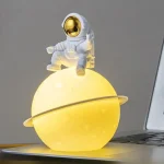 Dekoratives Raumfahrer-Design auf einem leuchtenden Planeten-Sockel, ideal für Science-Fiction-Fans und moderne Raumdekorationen.