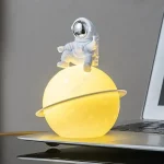 Dekoratives Sternenplanet-Design mit Astronautenfigur, leuchtend gelb, ideal für Science-Fiction-Dekorationen und Raumfahrt-Themen.