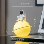 Kreative Lampe in Form eines Planeten mit Astronautenfigur, ideal für Wissenschafts- und Raumfahrtliebhaber, mit Maßen 9,8 cm x 12,1 cm.