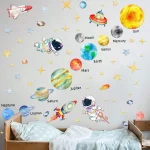 Wanddekoration mit bunten Planeten, Sternen und Raumfahrzeugen für Kinderzimmer, inspiriert von dem Sonnensystem.