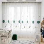 Helle Kinderzimmerdekoration mit weißen Vorhängen, die mit bunten Planeten und Raketen bedruckt sind, schafft eine freundliche Atmosphäre.