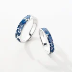 Eheringe mit Meeresmotiven, silberne Ringe mit blauer Emaille und Wellenmuster, symbolisieren Liebe und Naturverbundenheit.