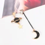 Elegante Ohrringe mit Stern-, Mond- und Planetenmotiven, kombiniert mit schwarzen Kristallen, ideal für Science-Fashion-Accessoires.