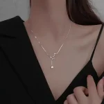 Elegante Halskette mit Sternenanhänger, getragen von einer Frau, die ein schwarzes Oberteil trägt. Perfekt für stilvolle Anlässe oder als modisches Accessoire.