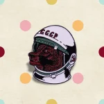Detailaufnahme eines Raumfahrer-Emblems mit sowjetischem Helm und rotem Tiermotiv, ideal für Wissenschafts- und Dekorationsliebhaber.
