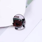 Detaillierter Abbild eines Pins mit einem Hund in einem Raumfahrerhelm, symbolisiert Wissenschaft und Abenteuer. Perfekt für Science-Gadgets und Dekorationen.