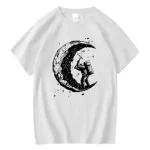 Weißes T-Shirt mit schwarzem Druck eines Astronauten, der auf einer halbmondförmigen Mondphase steht, umgeben von kleinen Sternen.