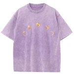Lila T-Shirt mit goldenen Mondphasen-Motiven, inspiriert von astronomischen Zyklen, auf weichem Stoff.