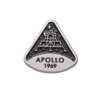 Detailaufnahme eines Apollo 11 Mondlandungs-Medaillons mit der Aufschrift "APOLLO 1969" und einer Raumfahrzeug-Illustration.