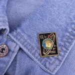 Astronauten-Pin mit Sternen-Design auf Jeansjacke, symbolisiert Weltraumforschung und Wissenschaft. Perfekt für Science-Fans und Astronomie-Enthusiasten.